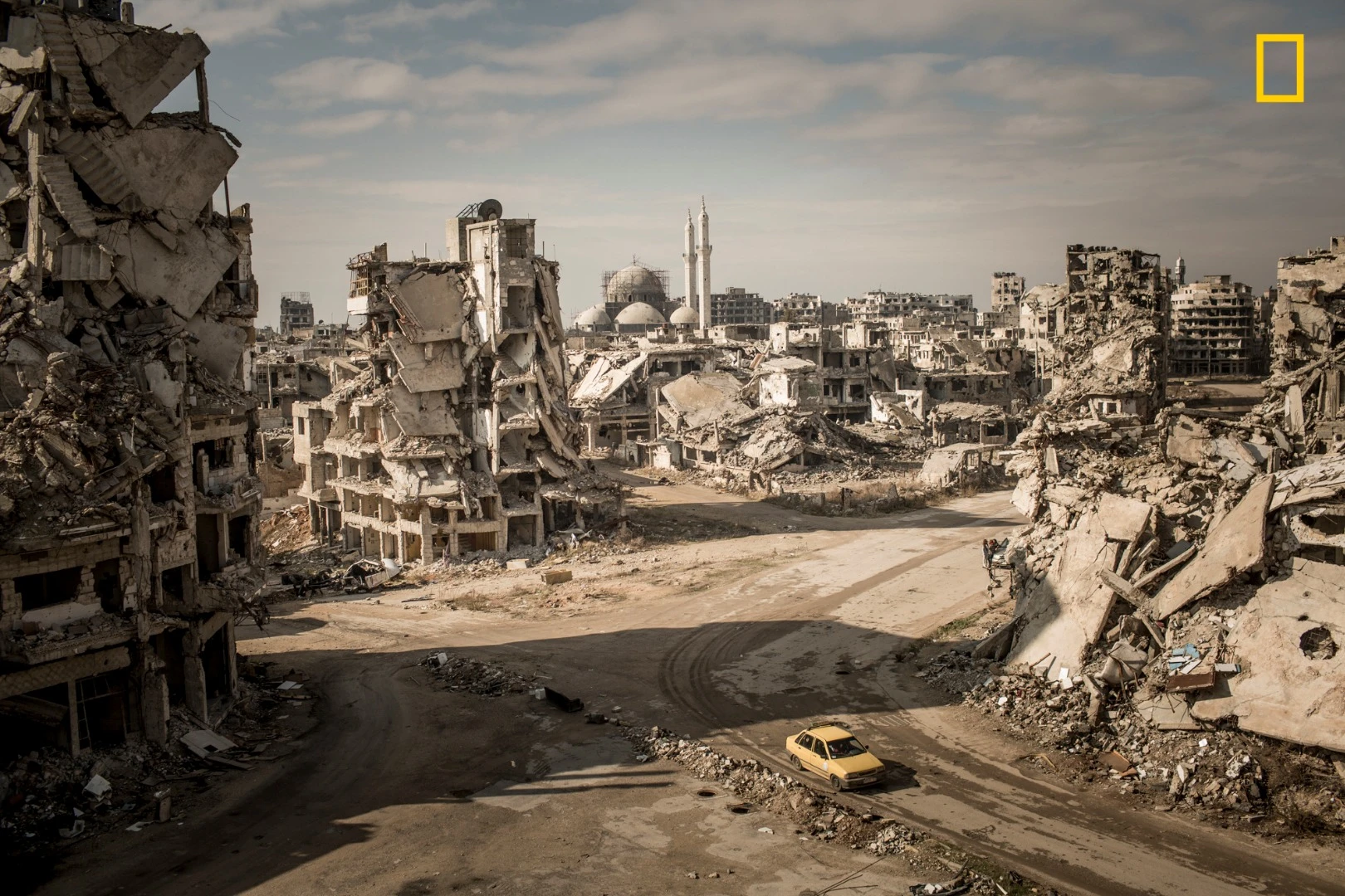 3rd Place - Places. While on assignment for Der Spiegel, we made a road trip through Syria to document the current situation in major cities. When I first entered the Khalidiya district in Homs, I was shocked. I hadn’t seen such large-scale destruction before, and I had been to many destroyed cities. The area around the Khalidiya district was extremely quiet. No city sounds, cars—nothing. Only the chirping of swallows and the wind. We walked down the streets of Khalidiya, but the destruction was so large scale that you couldn’t have the big picture from the point of view on the street—you could only manage it with a view from above. To make this image, I asked a Syrian soldier in charge of the area if I could climb onto a ruin. The soldier agreed, allowing me to climb at my own risk. I climbed up the ruins of a former house—which was full of improvised explosive devices—and took the picture. I was very lucky to take the picture when I was on the rooftop. Without any sign of life, it would have been a dead picture. I can recall the memory vividly.