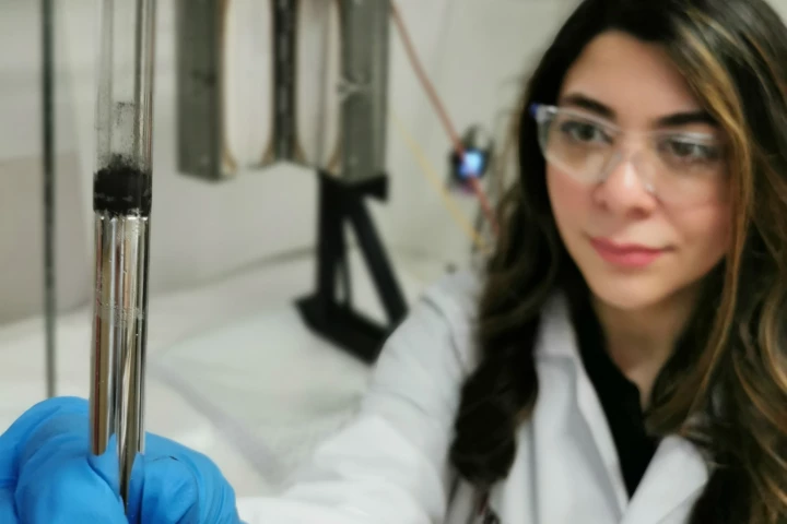 Karma Zuraiqi, lead author of the study, holds a vial of the liquid metal catalyst