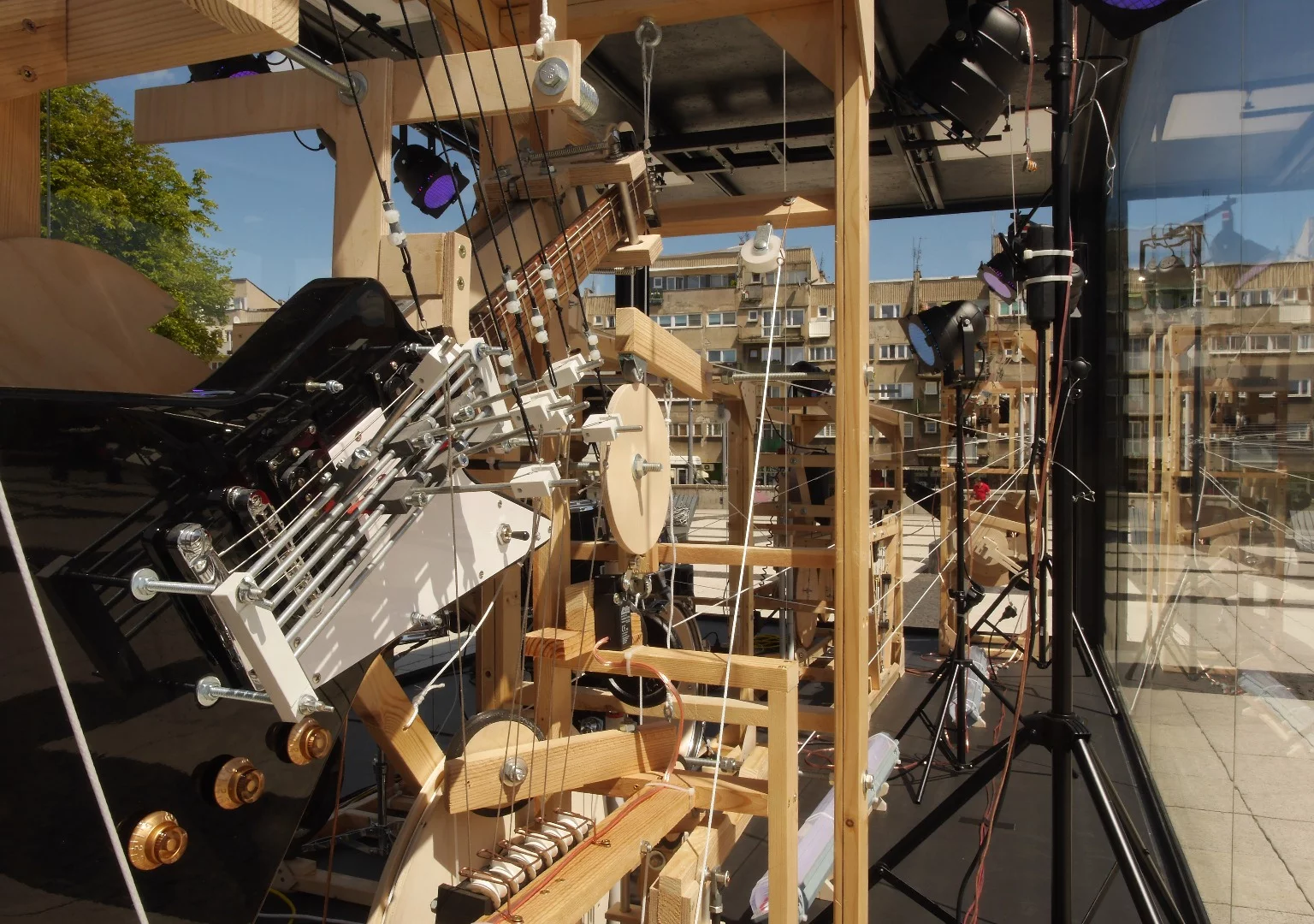 Across the neck is a steel bar that slides up and down to fret a note picked by one or more mechanical "fingers"