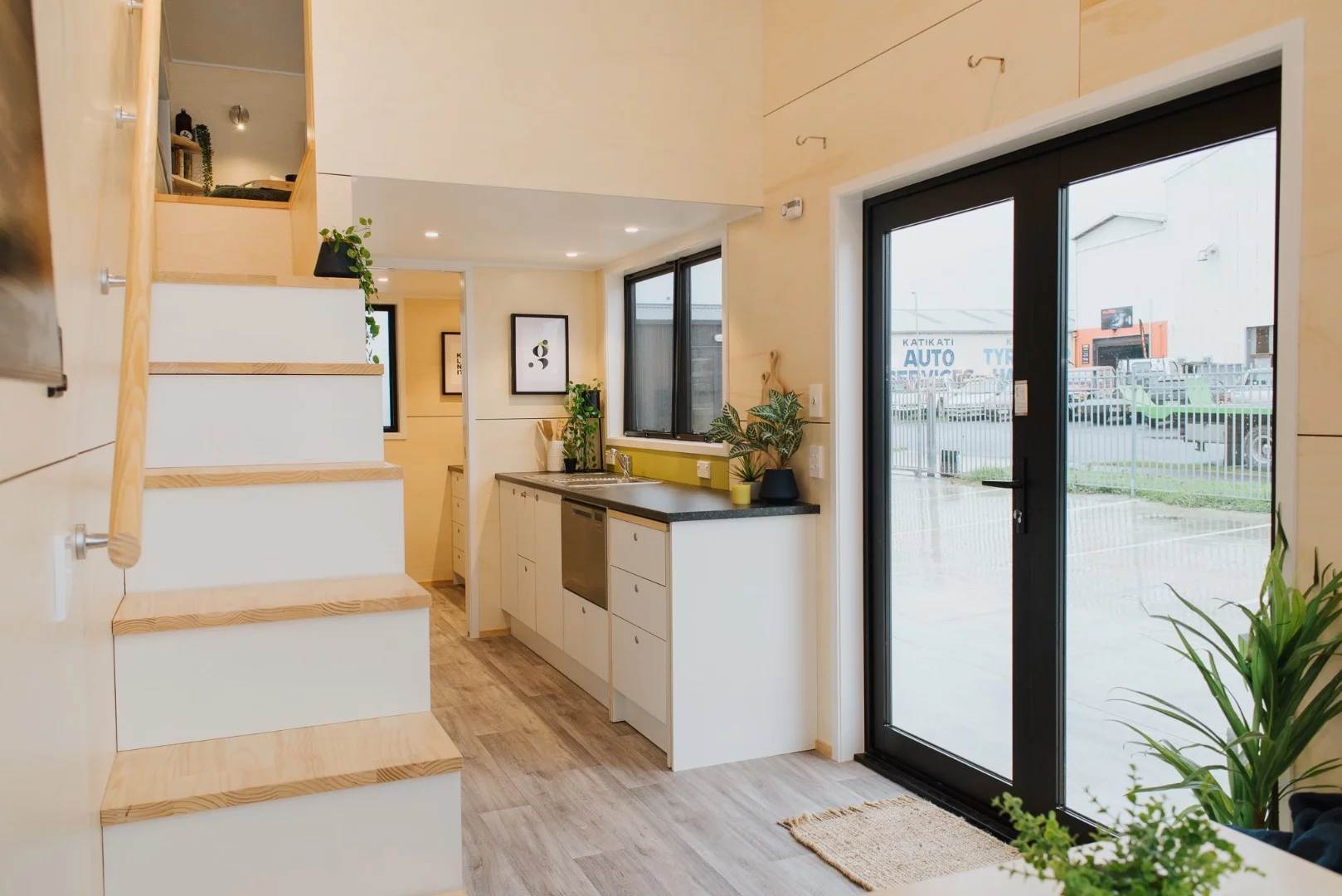 The Green Hill Farm Tiny House's storage-integrated staircase conceals a washing machine