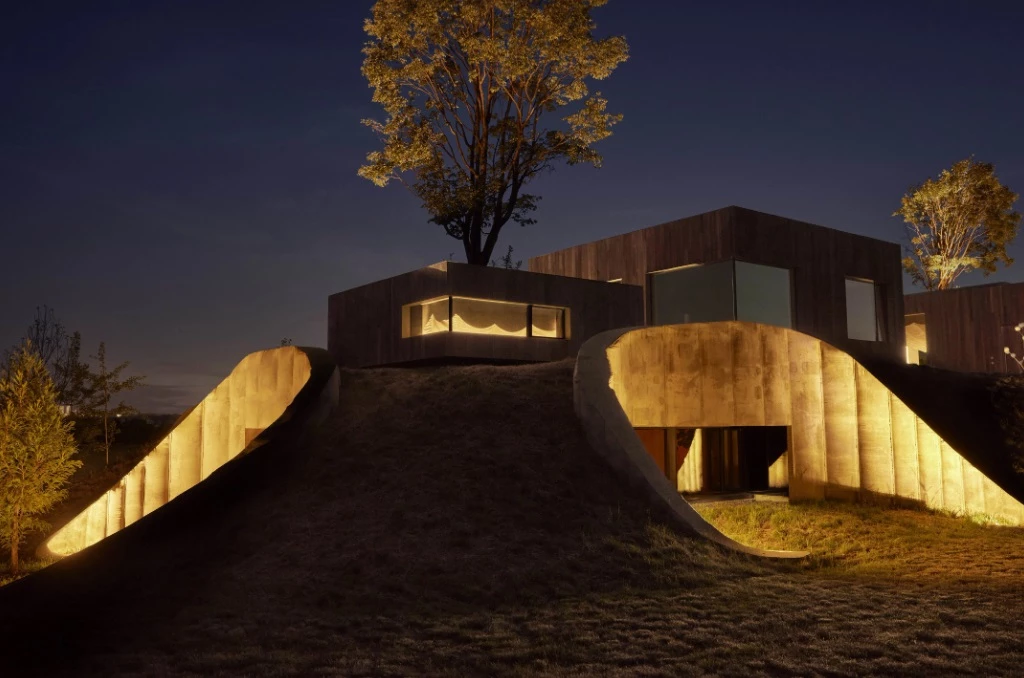 The interior lighting glows onto the surrounding landscape