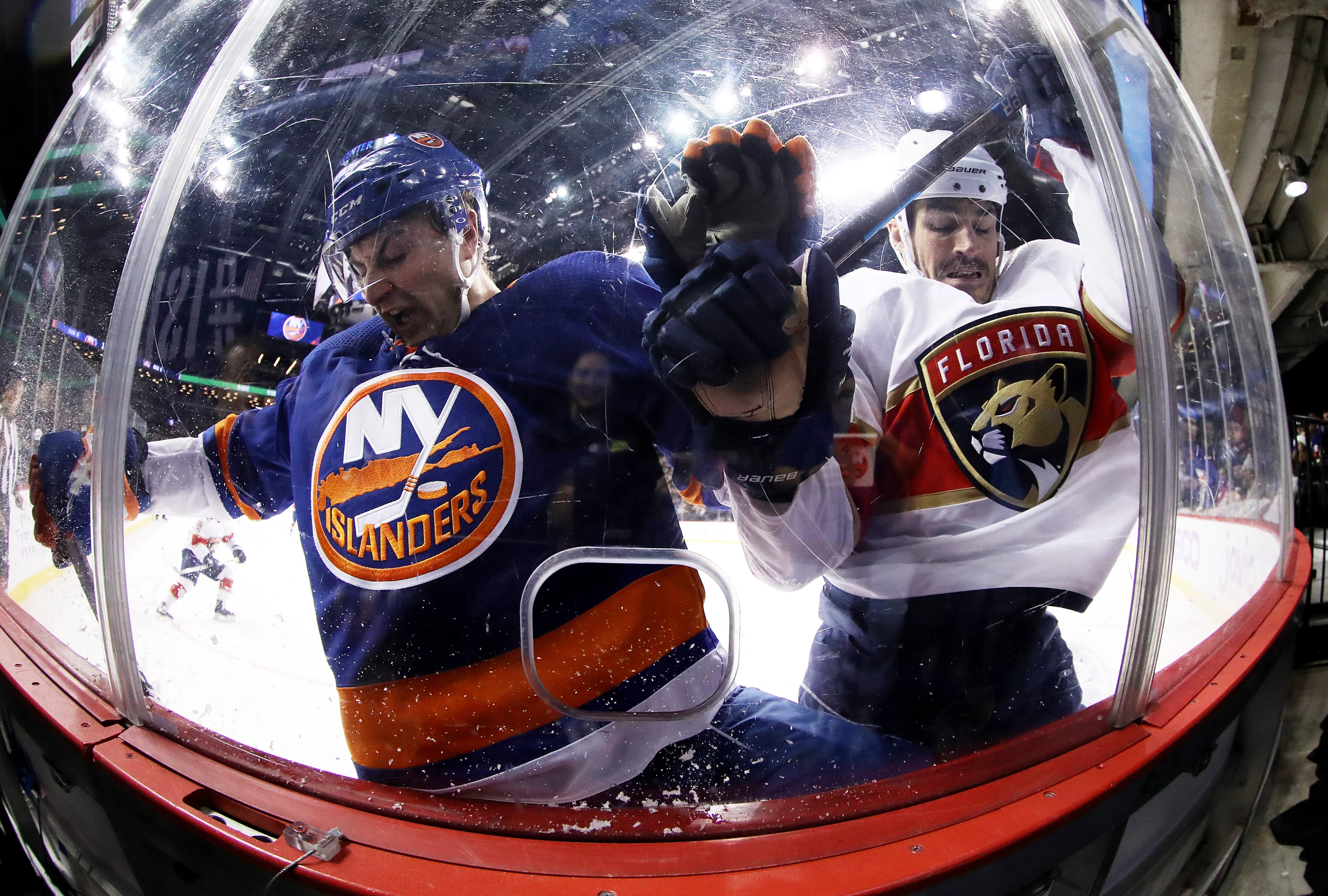 Silver, Determination. Adam Pelech of the New York Islanders and Brian Boyle of the Florida Panthers crash the boards during their game at Barclays Center on November 09, 2019 in New York City