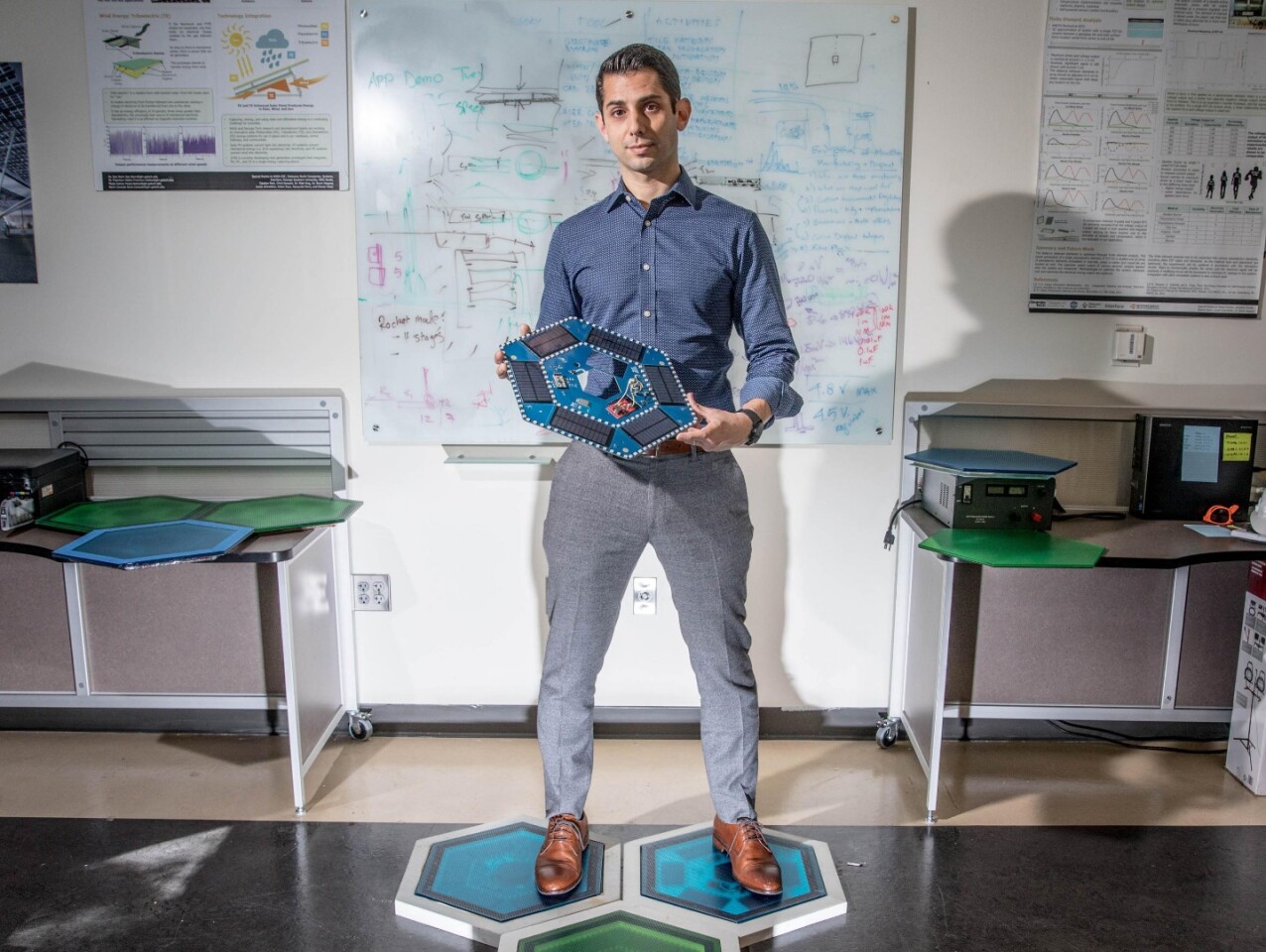 Ilan Stern, Georgia Tech research scientist, standing on the tiles that will soon be installed at NASA's Kennedy Space Center and holding the electronics inside