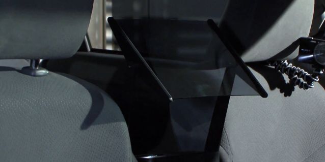 The half-mirror, which reflects the projected video onto the back seat