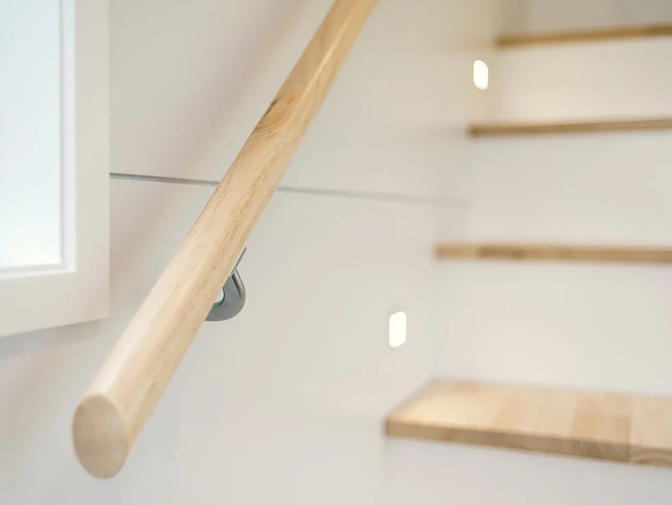 The Buster Tiny House's bedroom is reached by storage-integrated staircase