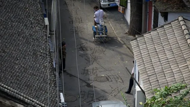 Artist Nicholas Hanna has created a cargo tricycle-based system that prints Chinese calligraphy on the road, in water