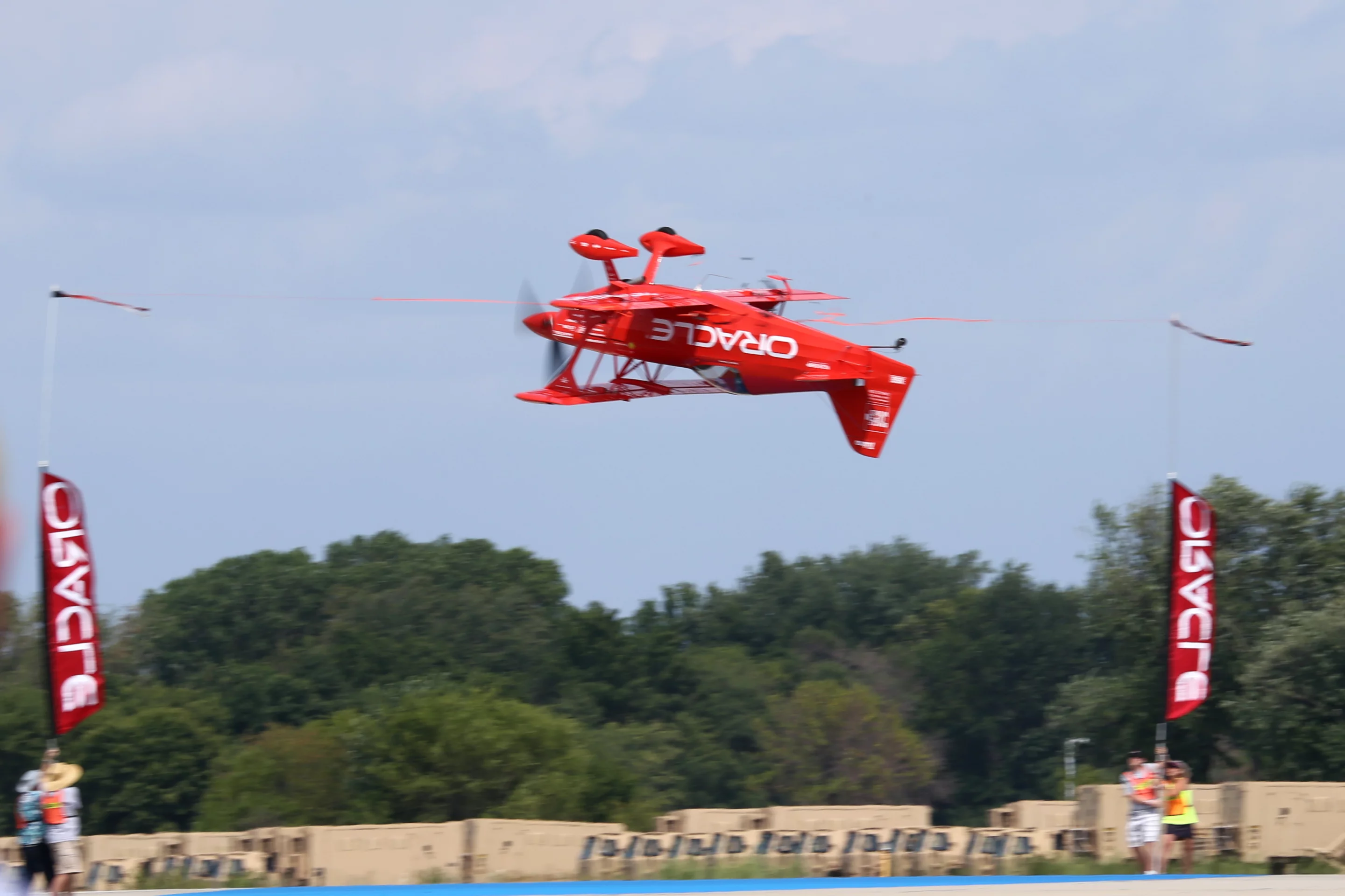 The Oracle aerobatic plane cutting ribbon number three in the inverted position (Photo: Angus MacKenzie/Gizmag.com)