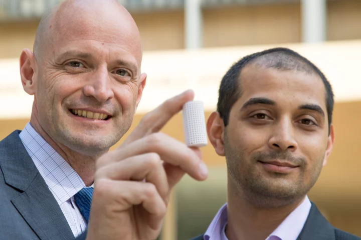 J.R. DeShazo (left) and Gaurav Sant show off a sample of the new building material they have created to replace conventional concrete