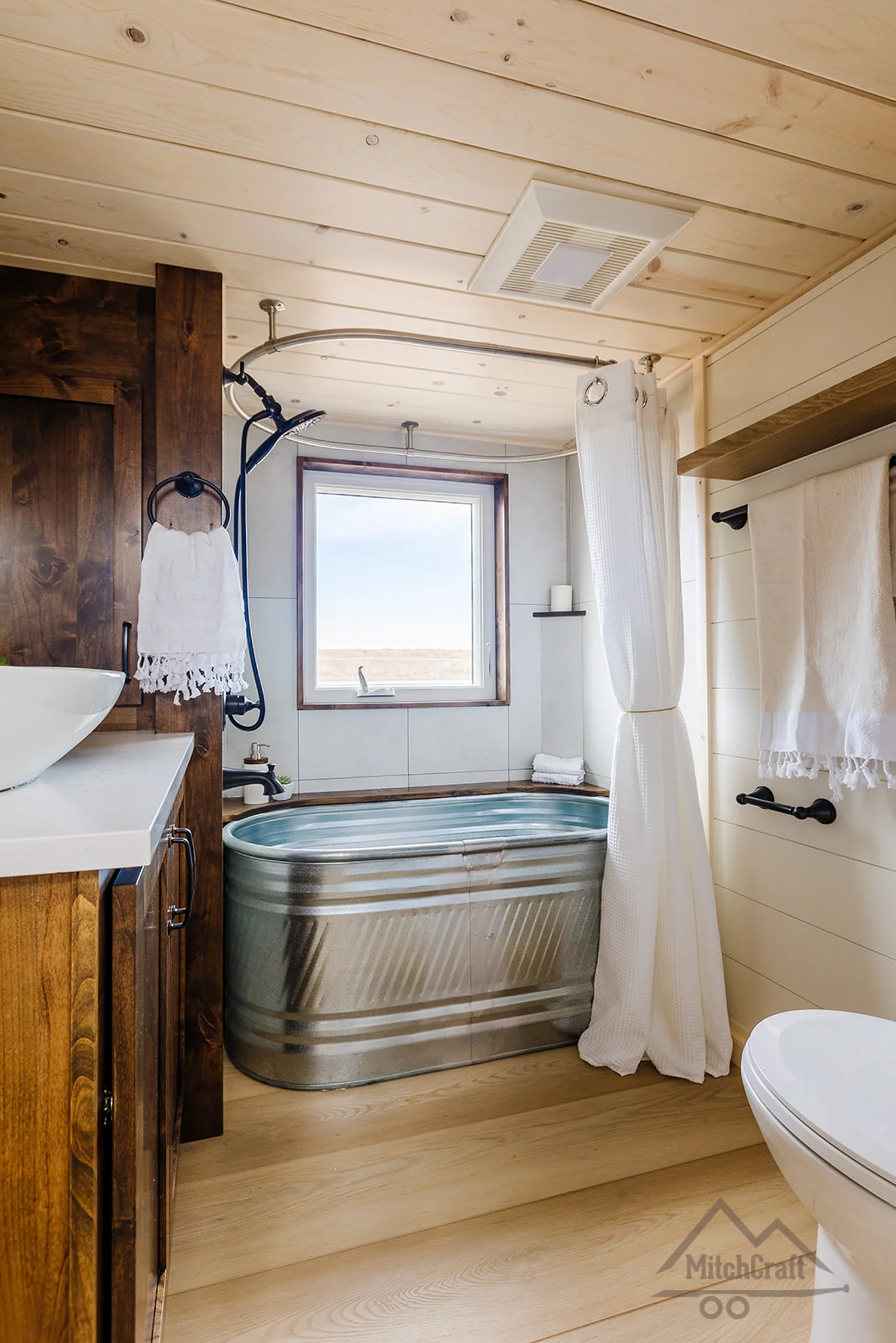 The bathroom in the CC 31' x 10' includes a horse trough-style soaking tub with a shower, plus a sink and flushing toilet
