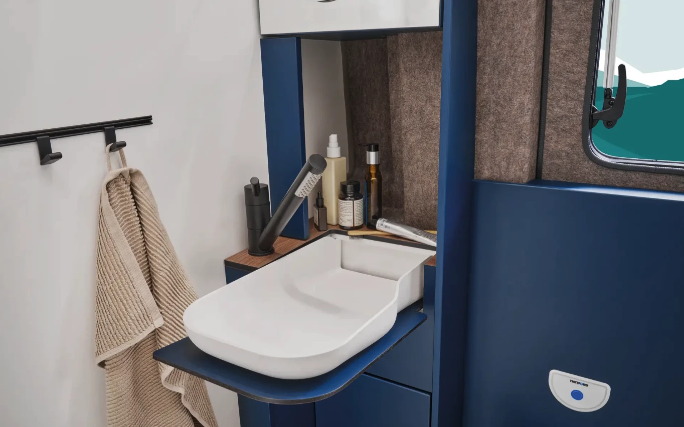 The bathroom sink folds out of the way when not in use, clearing extra space for showering