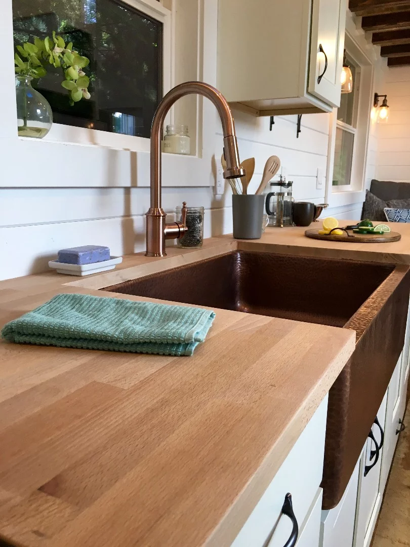 The kitchen in the Rocky Mountain Tiny Home includes a neat copper sink