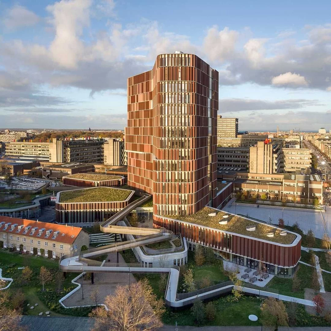 Maersk Tower, Extension of the Panum Complex at the University of Copenhagen, Denmark by C.F. Møller Architects. A winner under the "Skyscrapers and High Rises " category at the 2018 International Architecture Awards, this building is wrapped in a glass facade to promote a connection with its green surroundings