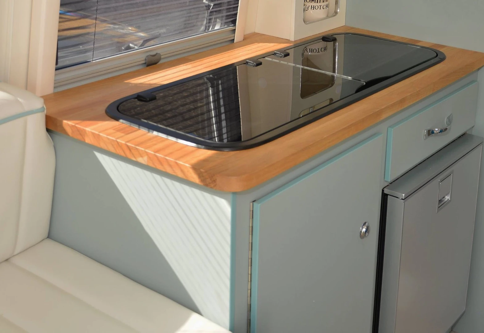 The kitchen unit has a two-burner stove and sink under its glass top