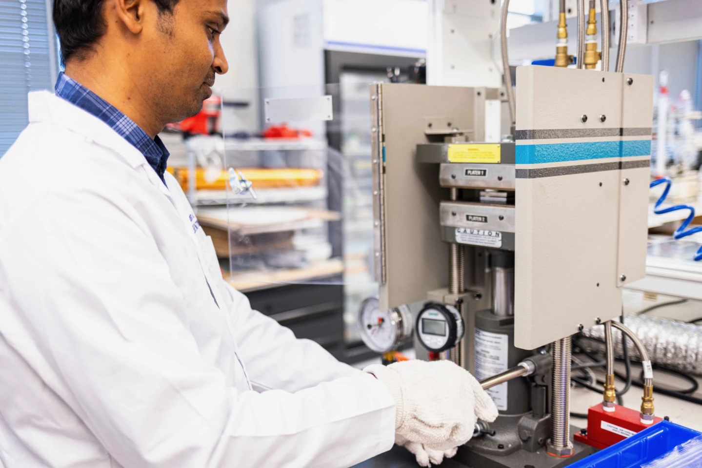Agni K. Biswal, a University of Washington postdoctoral scholar in mechanical engineering, uses a heat press to laminate a vitrimer printed circuit board