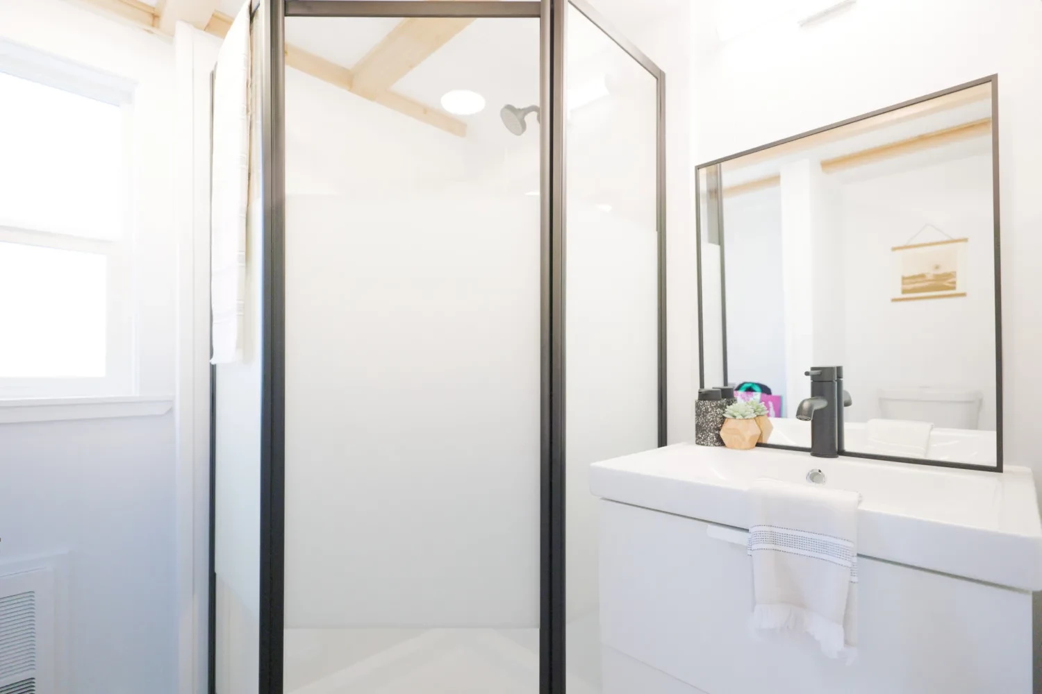 The Ventura Park Model Tiny Home's bathroom includes a shower, sink, and flushing toilet