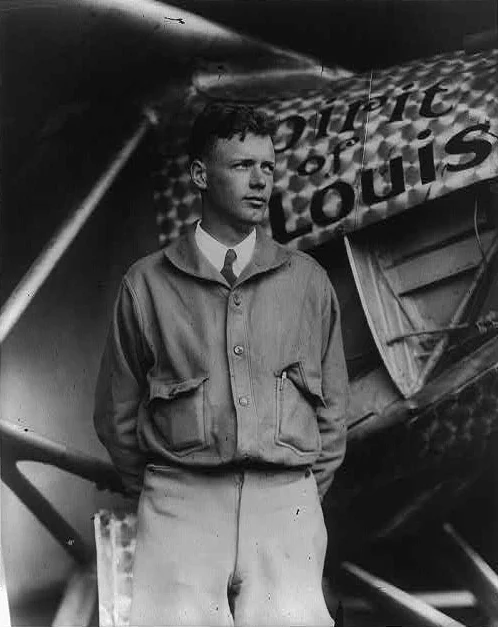 Charles Lindbergh standing next to the Spirit of St Louis