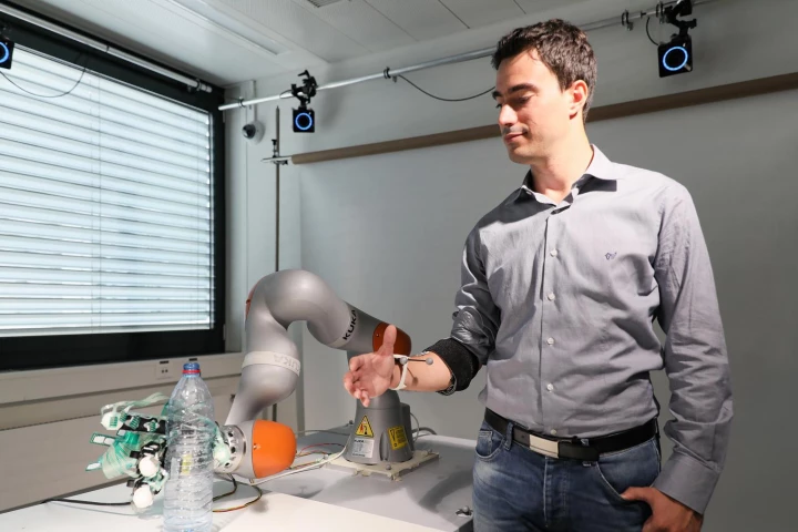 Researcher Artoni Fiorenzo demonstrates the shared control system, using a robotic arm