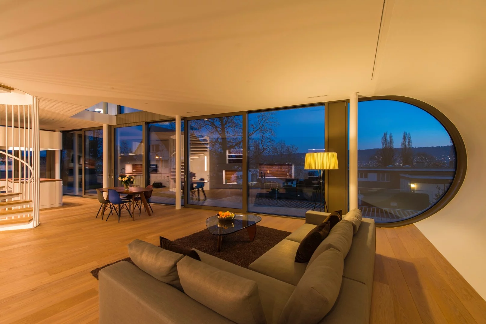 The house is sandwiched between a road, a railway line, and the edge of a village