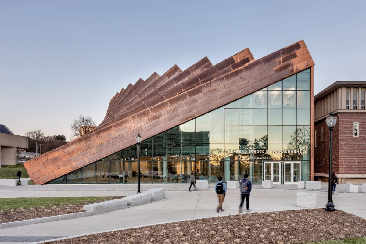 The Business Innovation Hub's exterior features vertical copper pillars, which gradually slope downward, forming a large triangular entrance