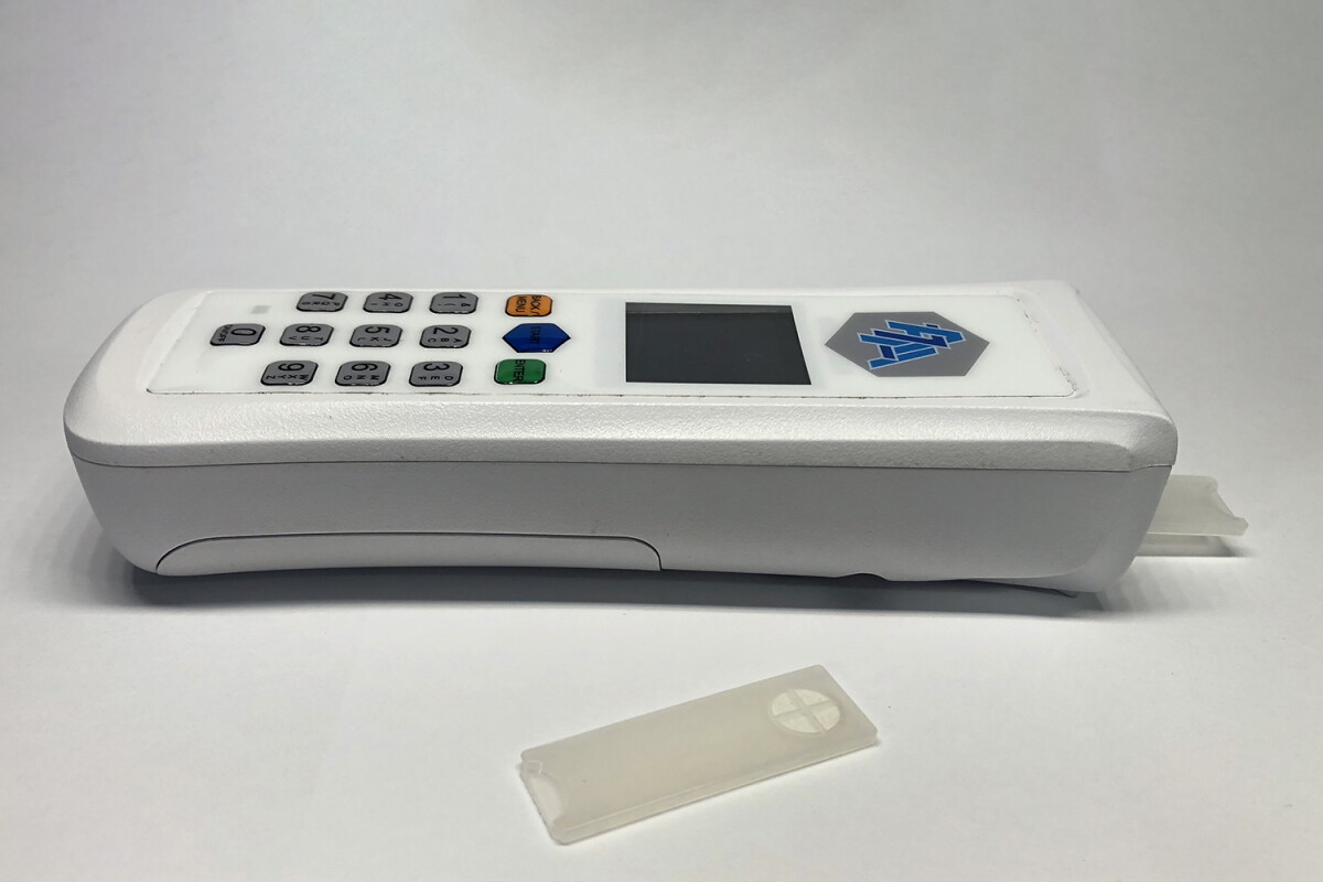 The device (pictured here with one of its test strips) could be used either by staff in clinics, or by patients in their own homes