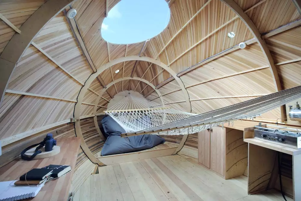 The Exbury Egg's interior includes a desk, hammock, and kitchen, with paraffin stove and sink