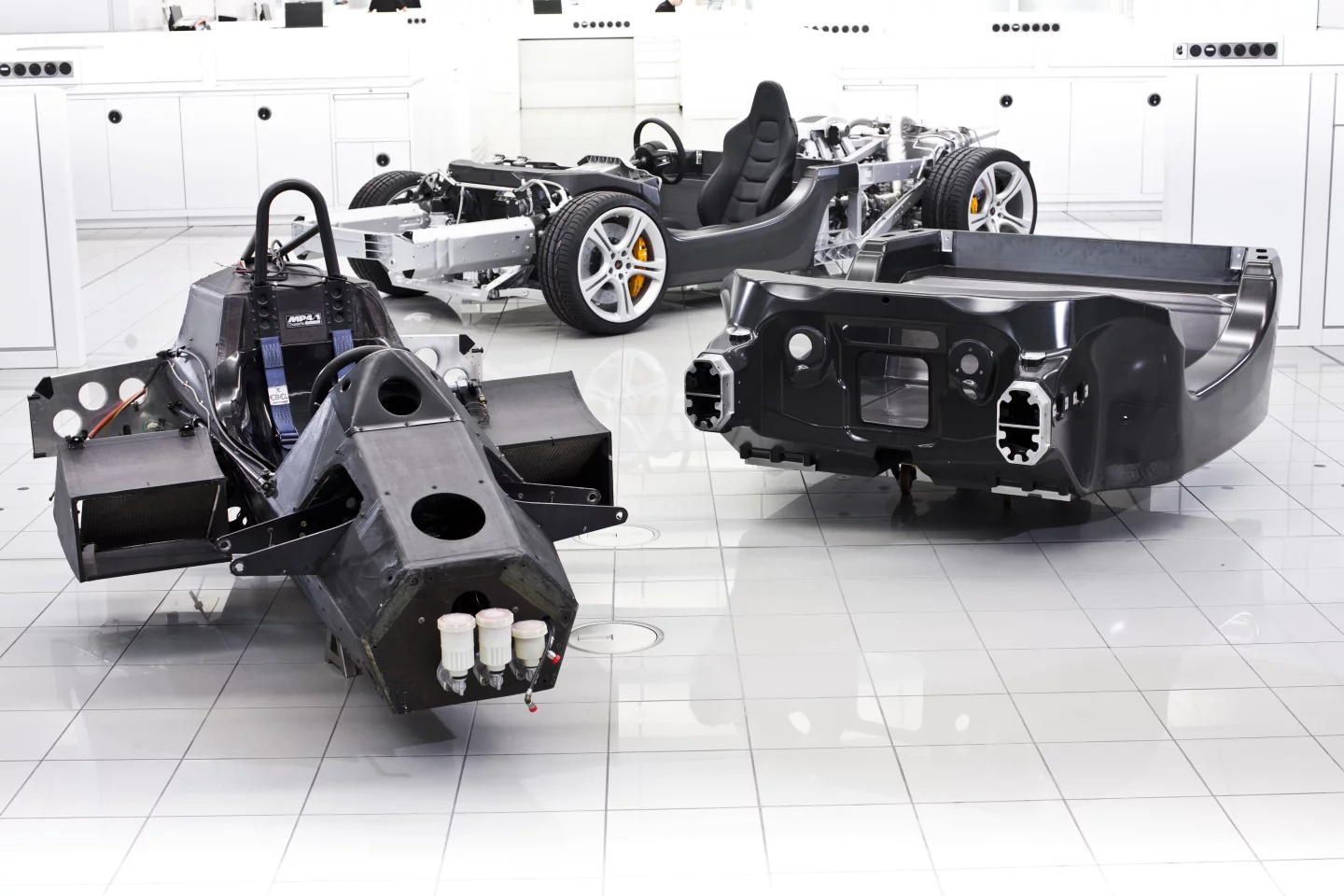 MP4/1 pilot cage (left) displays design similarities to the 12C's monocoque, which demonstrates how the composite tub is used as a mounting point for the engine and forward structural components