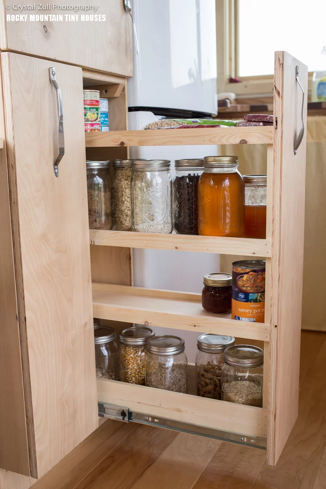 A custom-made pantry with pull-out shelves for canned goods