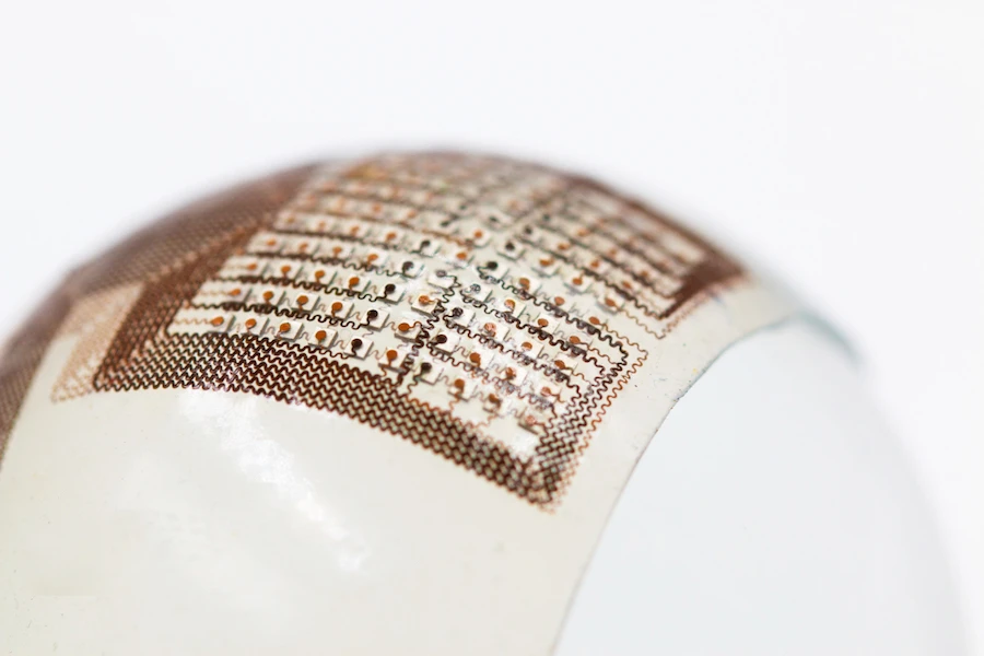 The patch consists of a thin silicone elastomer sheet with an embedded "island-bridge" electronic structure