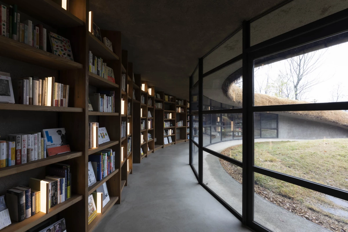 A series of curved windows bring natural sunlight into the subterranean space, while also connecting visitors with the surrounding nature