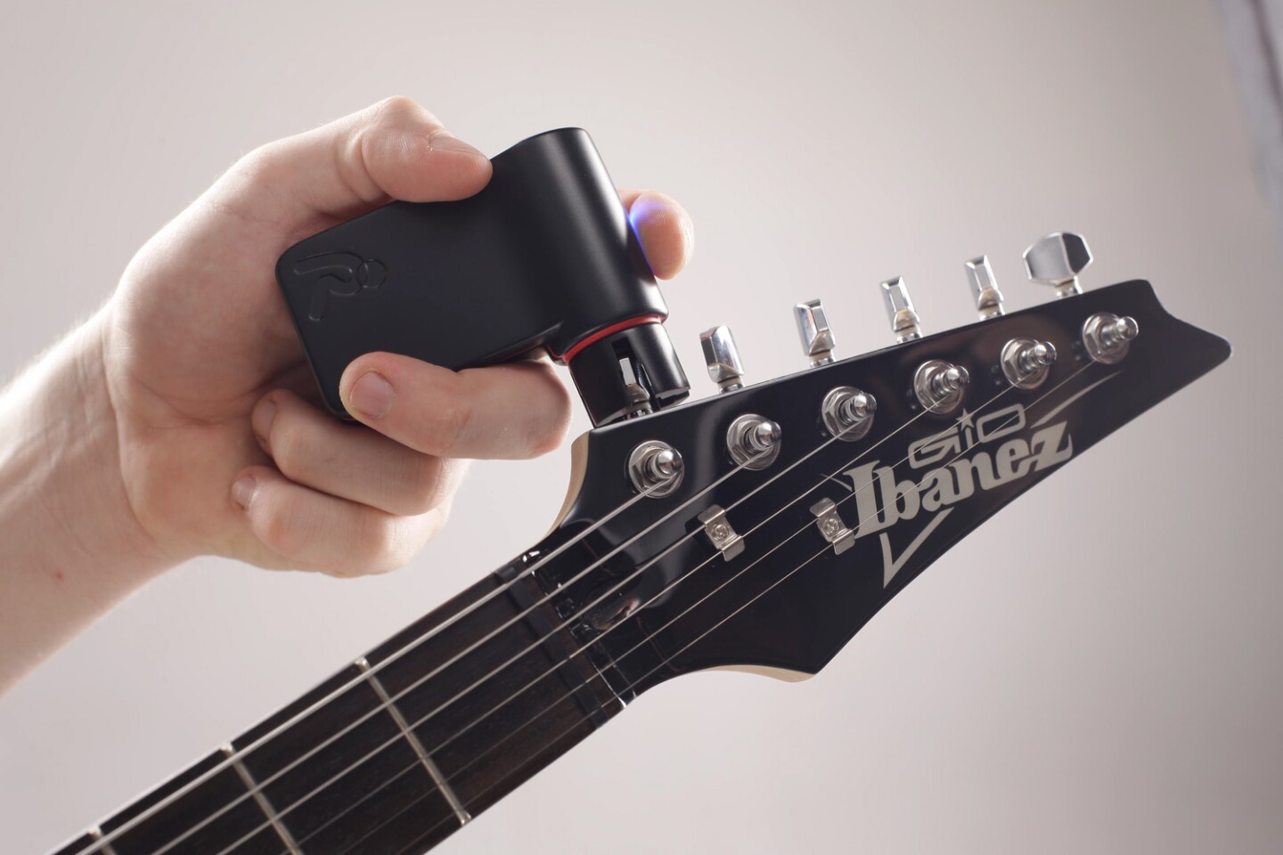 The Roadie Tuner's motorized grip tightens or loosens each tuning head to bring the guitar to tune