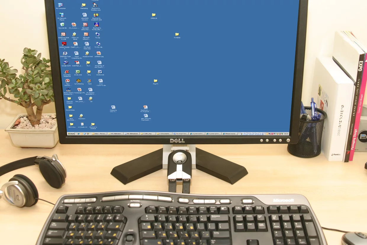 The Plug PC being dwarfed by monitor and keyboard in a typical desktop setting