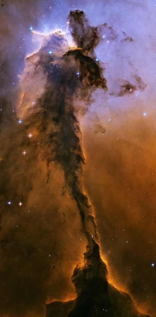 Another billowing pillar in the Eagle Nebula, this one stretching 9.5 light-years tall. The top section is bathed in UV light from a cluster of young stars off the top of the image, which is slowly eroding the formation.