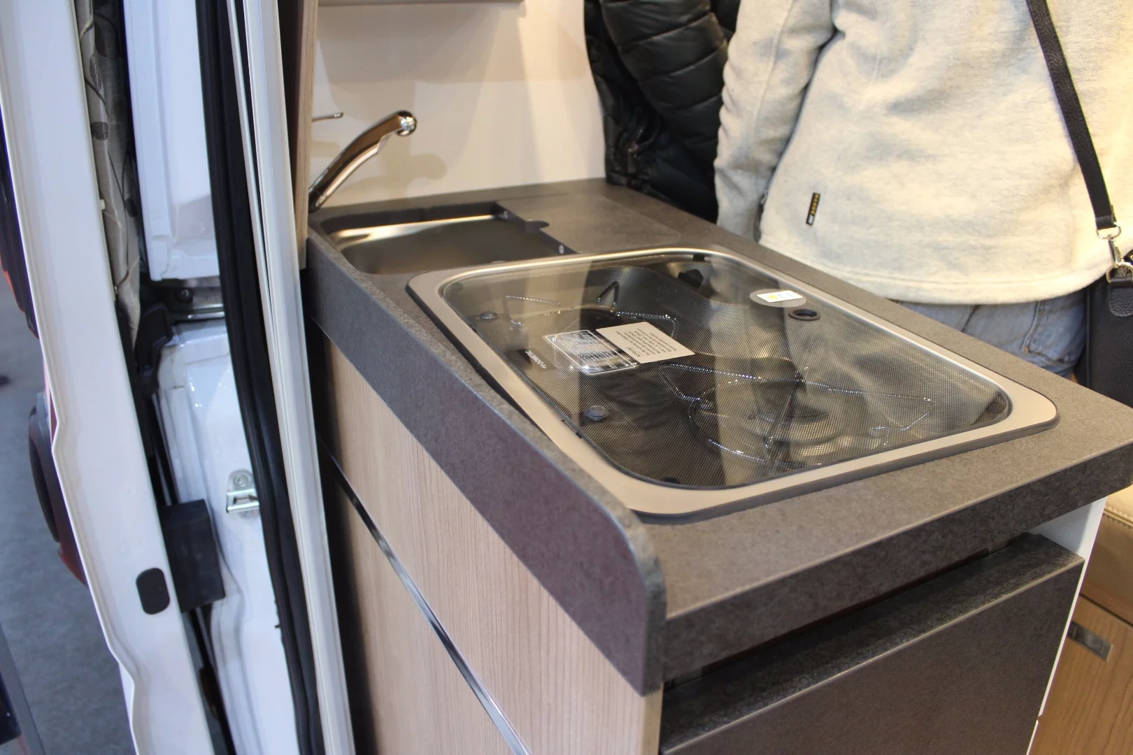 The Charming GT has a compact kitchen block with dual-burner stove and fridge, a refrigerator next to it