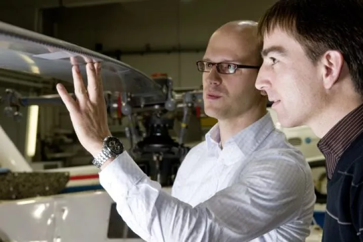 Kai Richter (left) and Holger Mai of DLR inspect the installation of humpback whale-inspired "LEVoGs" on the test helicopter