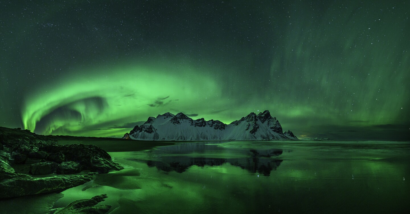 Aurorae. 'Stokksnes Aurora'. In order to get the shot, the photographer ended up knee-deep in the North Atlantic in -6 degrees Celsius. The challenge was to capture the reflections in the water, on the black sand beach, and also not to over-expose the aurora