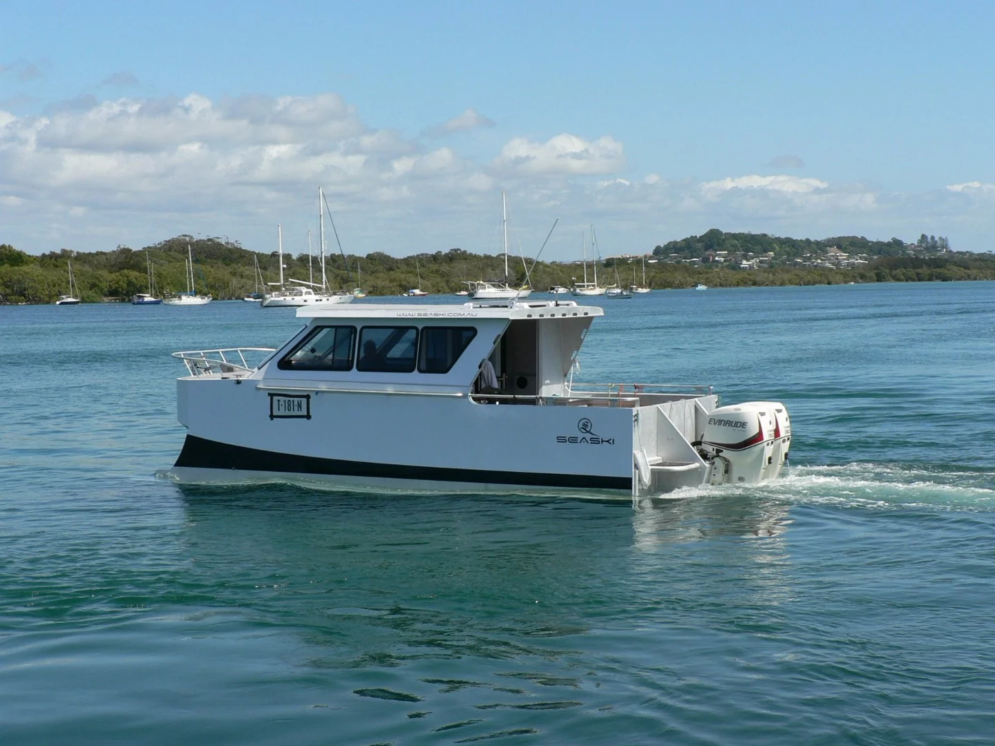 The 7-m (23-ft) vessel with its skis submerged at slow speed or moored at Fingal Boat Harbour, Northern New South Wales, Australia – it has a very wide beam at 3 m (9.8 ft)