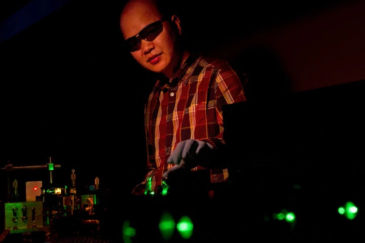 Cuong Dang manipulates a green beam that pumps Brown University's new nanocrystals with energy