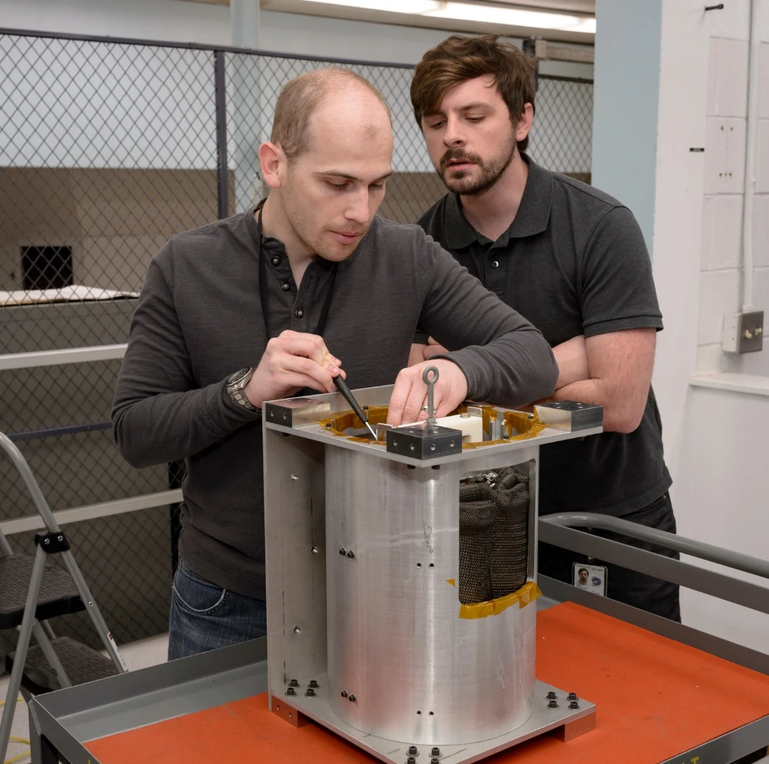 Brandon Smith, ADEPT principal investigator, and Joseph William, system engineer, in the entry systems and vehicle development lab at Ames perform final checks to the first ADEPT flight unit prior to a deployment test