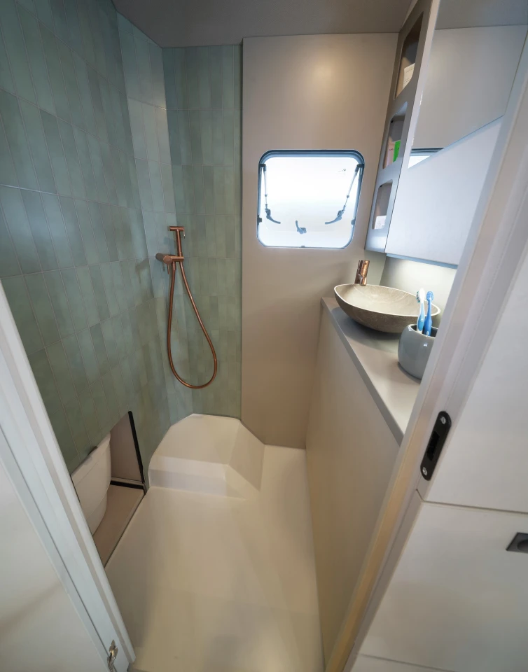 Slide the toilet away and rotate the sink back and the bathroom offers more elbow and leg room for showering