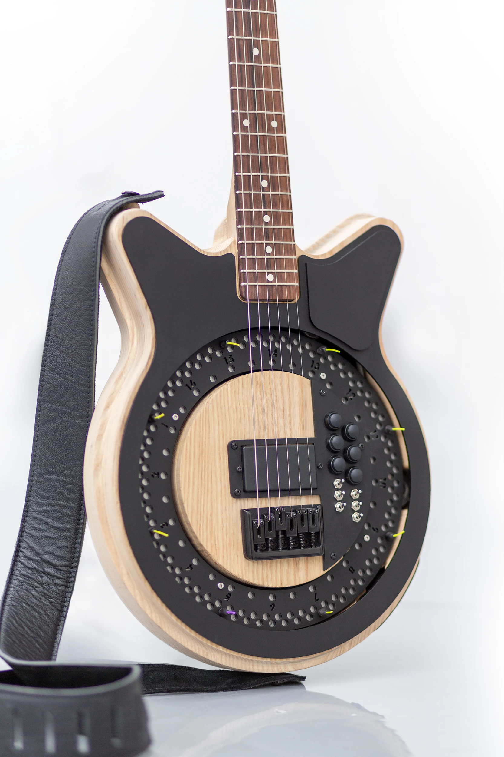 The motor-driven disc has guitar picks attached to it, which strike the strings when it spins up