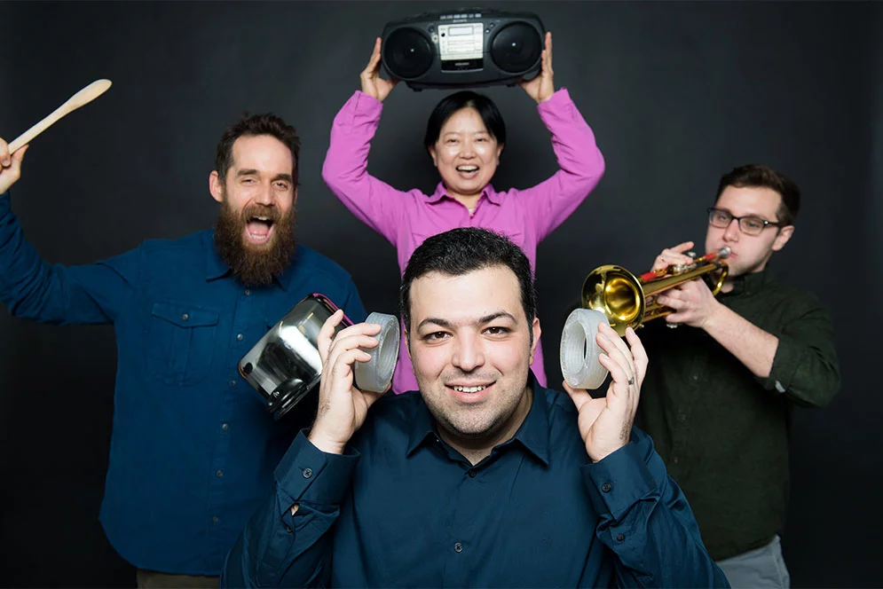 The researchers, Reza Ghaffarivardavagh (front center), Stephan Anderson (left), Xin Zhang (rear center), and Jacob Nikolajczyk (right), "demonstrate" the new acoustic metamaterial devices