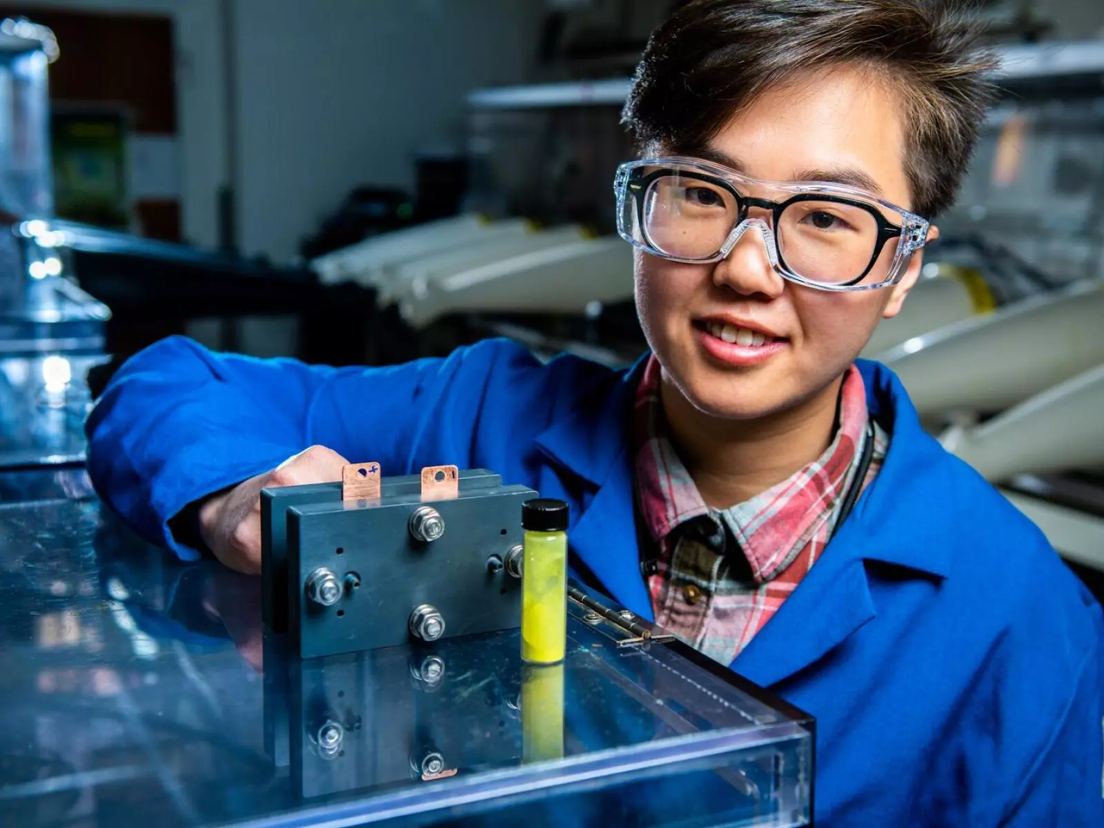 Flow battery researcher Ruozhu Feng poses with ingredients for a long-lasting grid energy battery