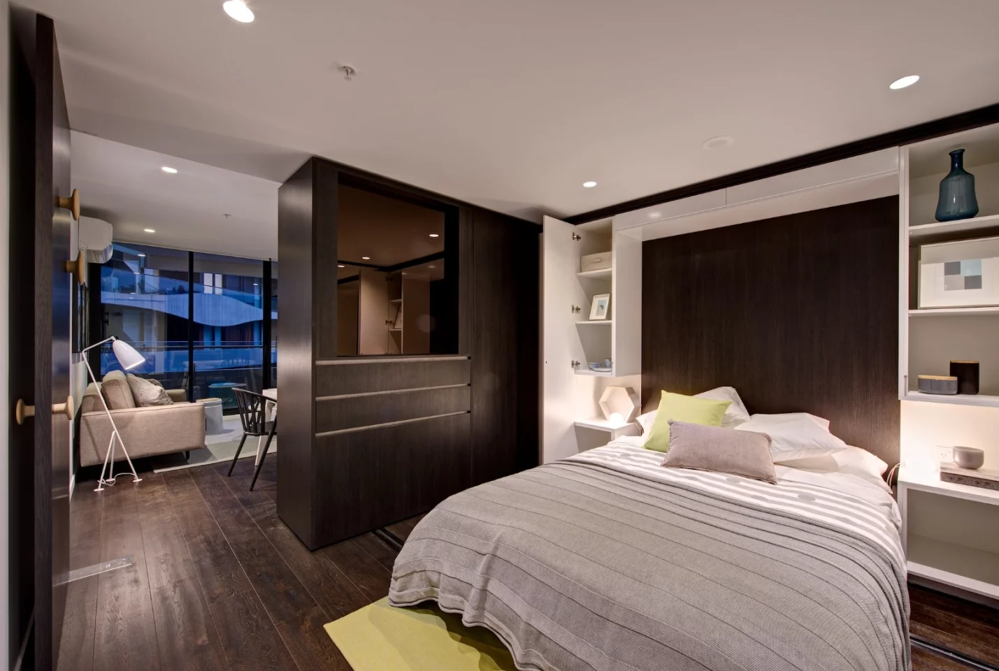 A bed is folded out from the wall in the newly created sleeping area, and bedside tables and storage can also be opened up