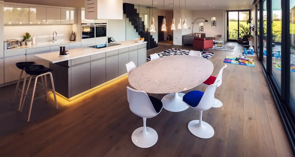The Kiss House features open-plan living on the ground floor, with a large modern kitchen, wooden flooring and floor-to-ceiling glass window