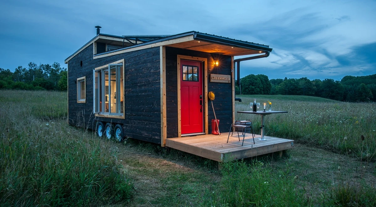 The Greenmoxie Tiny House has a drawbridge deck, which allows the tiny house to remain a reasonable length for towing but then extend when stationary to offer a generous outdoor deck area