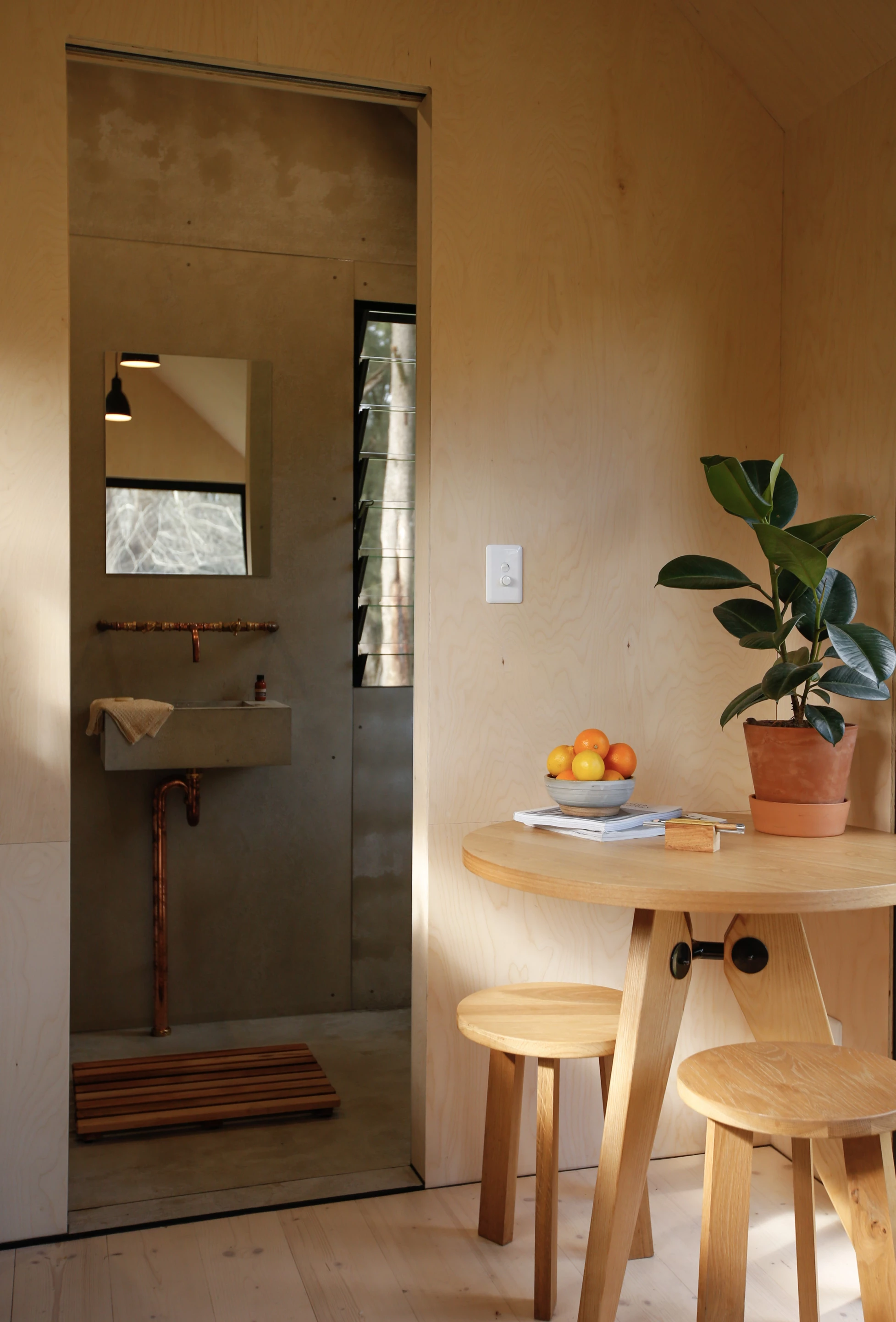 The Barrington Tops Cabin's bathroom is finished in fiber cement sheets, giving it an unfinished concrete look