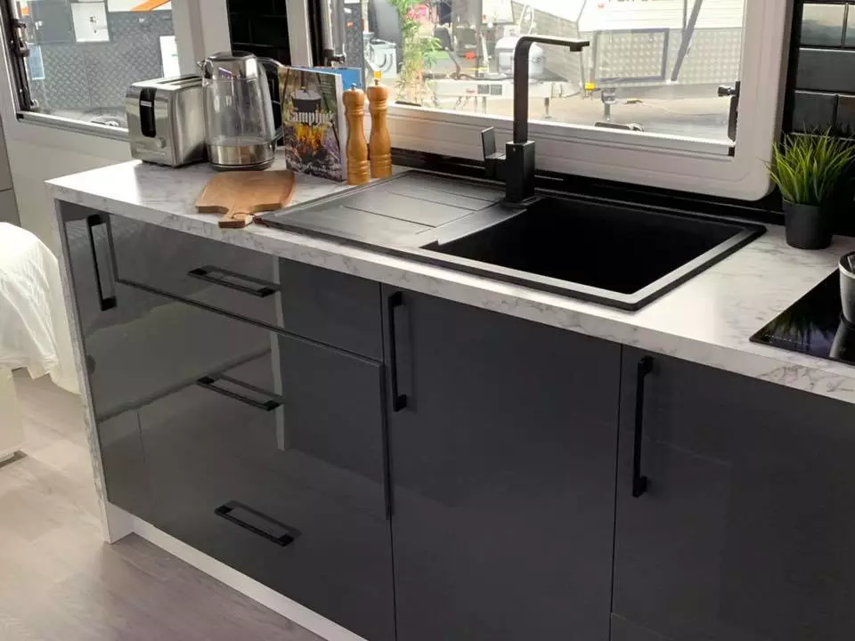 The kitchen includes a sink, induction cooktop, fridge and oven/grill and can support plenty of accessories