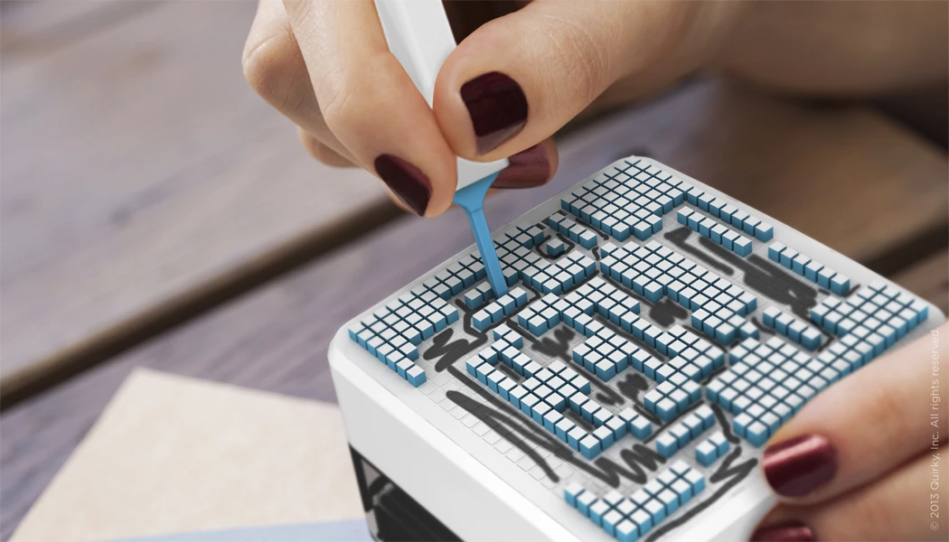 Using a tool built into the Pixit pen, you press down each little square, locking them all into place