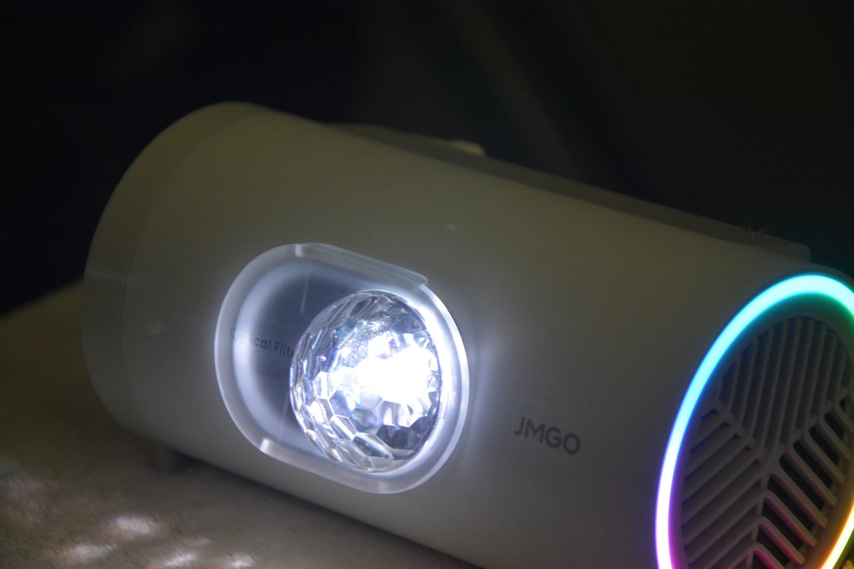 The optical filter is positioned over the projector's lens, snapping into place