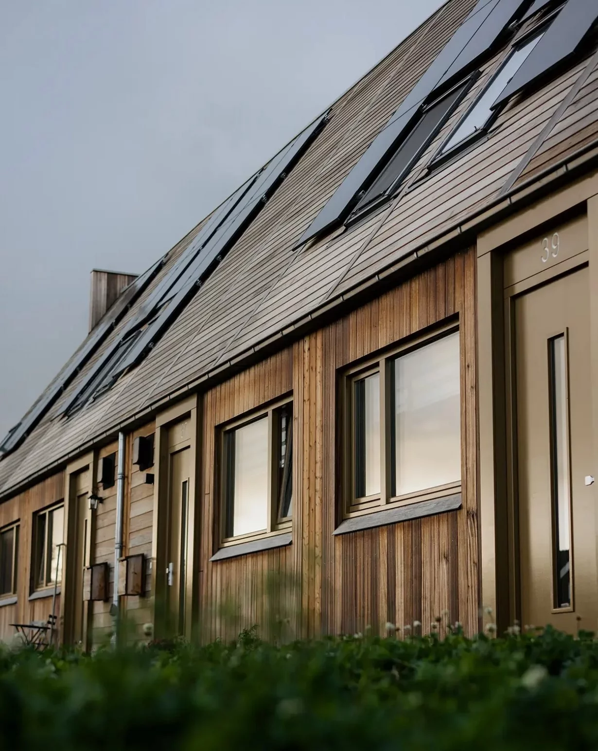 The houses feature a breathable wall system with a self-regulating indoor climate